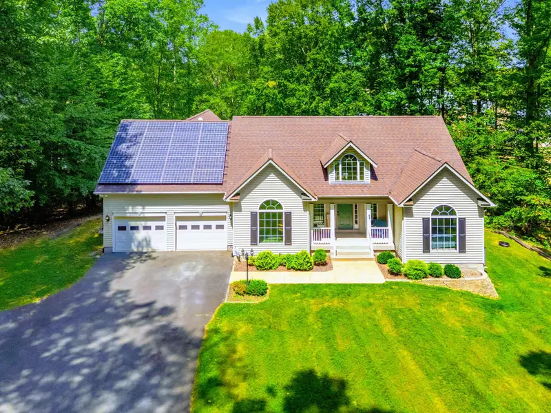 Overhead view showing the roofline, expansive yard, and wooded lot. Private and spacious.
