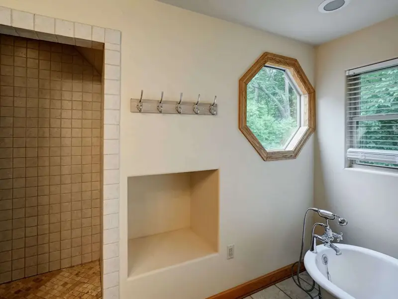 Soak, Then Sleep - A tile shower with an octagonal window and a freestanding tub make the loft bath truly special.