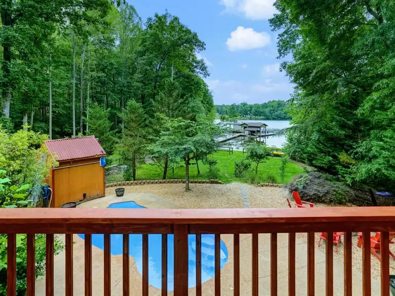 A View Worth Staying For - The deck railing frames a picture-perfect look at the pool and shimmering lake.