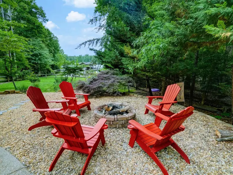 Fire Pit Nights - Red Adirondack chairs circle the fire pit for evenings filled with stories and s'mores.
