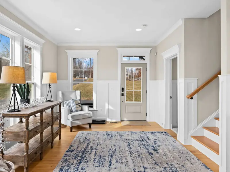 Foyer - A craftsman entry with hardwood floors, wainscoting, and an open staircase sets a warm welcome.