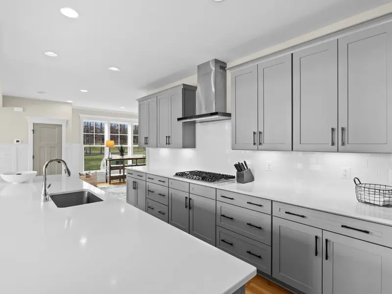 Kitchen - Gray shaker cabinets, quartz countertops, and a 5-burner gas range anchor a kitchen built for real cooking.