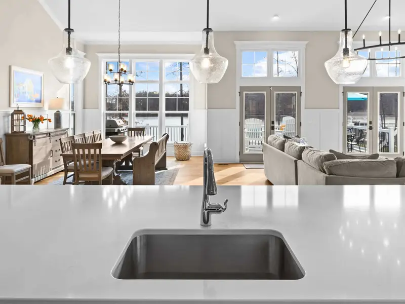 Kitchen - Looking from the island toward the great room, the open plan connects cooking and conversation under pendant lights.