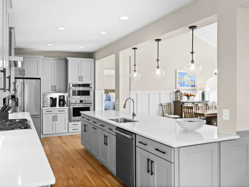 Kitchen - The full kitchen run from island to appliance wall shows generous counter space and clean-lined cabinetry.