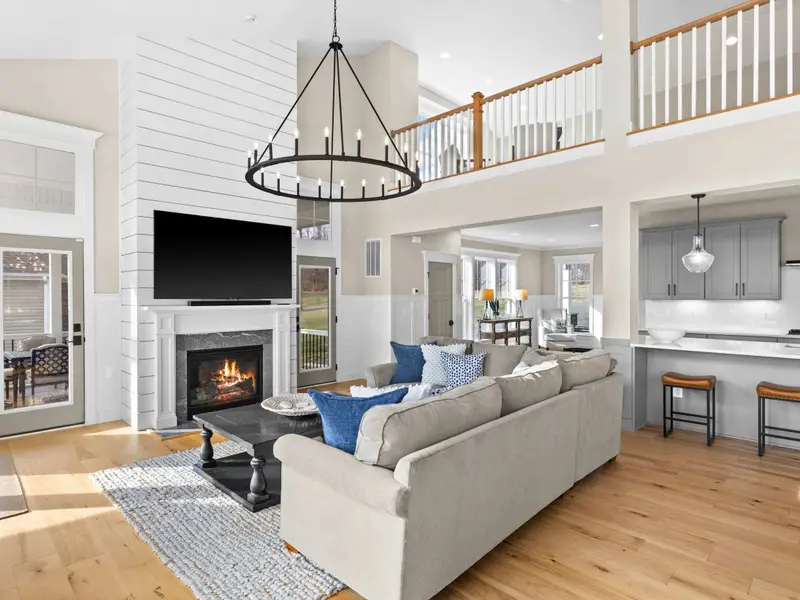 Great Room - A wide view captures the kitchen, living, and dining areas in one frame, all connected under vaulted ceilings.