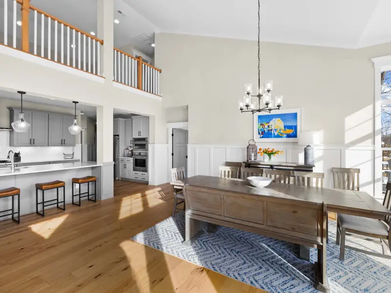 Dining Room - A long dining table with mixed bench and chair seating opens to the kitchen on one side and the lake on the other.