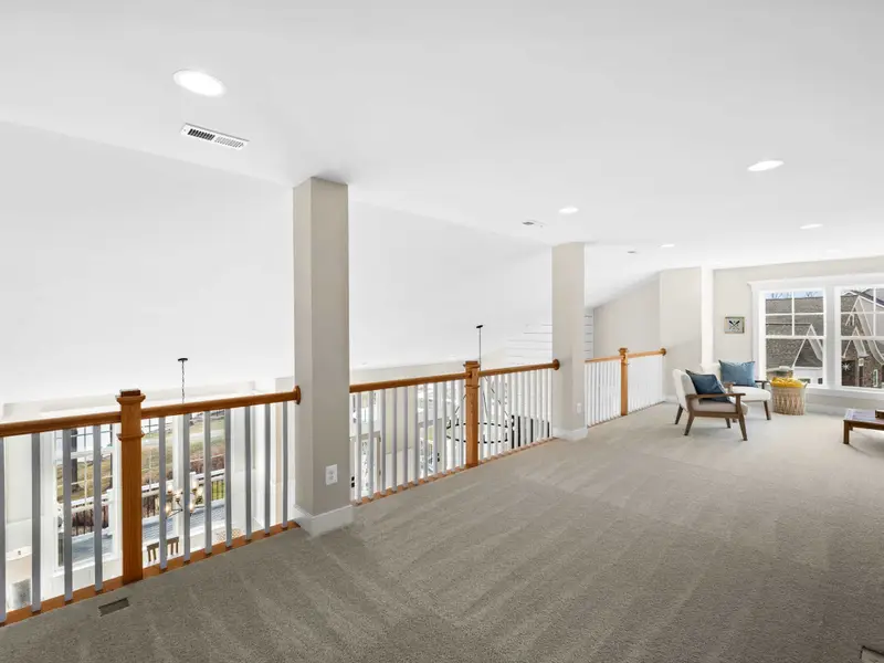 Loft - A sitting area in the loft with chairs and a low table, a quiet spot above the activity of the main floor.