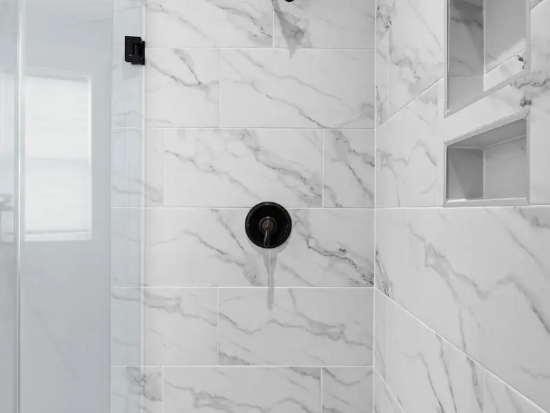 Primary Bathroom - Shower tile detail with matte black hardware and built-in niche, the kind of finish that rewards a slow morning.
