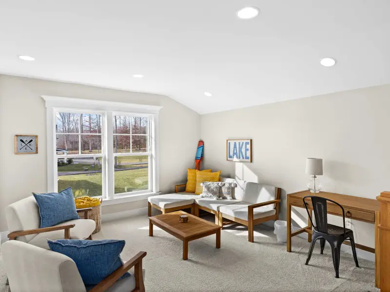 Loft - The loft sitting area with a 'LAKE' sign, wicker chairs, and sloped ceilings that give it its own cozy character.