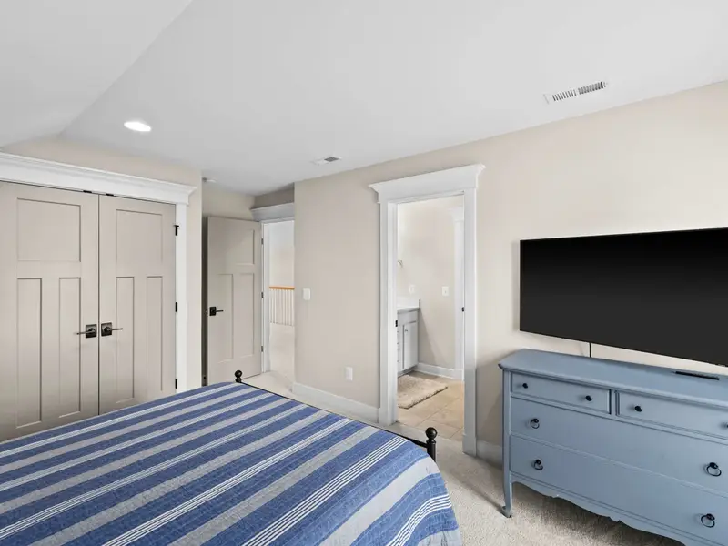 Queen Bedroom - Another view of the upper queen bedroom showing the dresser, closet doors, and en-suite access.