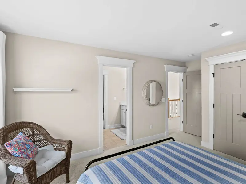 Queen Bedroom - A wicker chair by the window and the en-suite doorway, this upper bedroom has its own quiet corner.