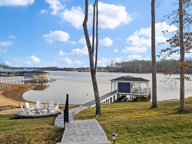 Boathouse - The path from the fire pit leads to the covered boathouse over the water, with Adirondack chairs and a kayak rack along the way.