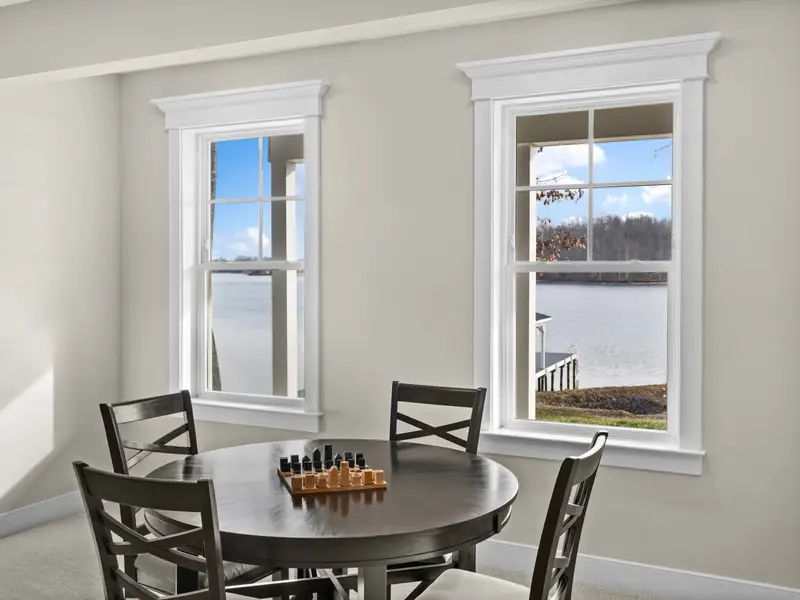 Game Room - A round game table with chess set and two lake-view windows.
