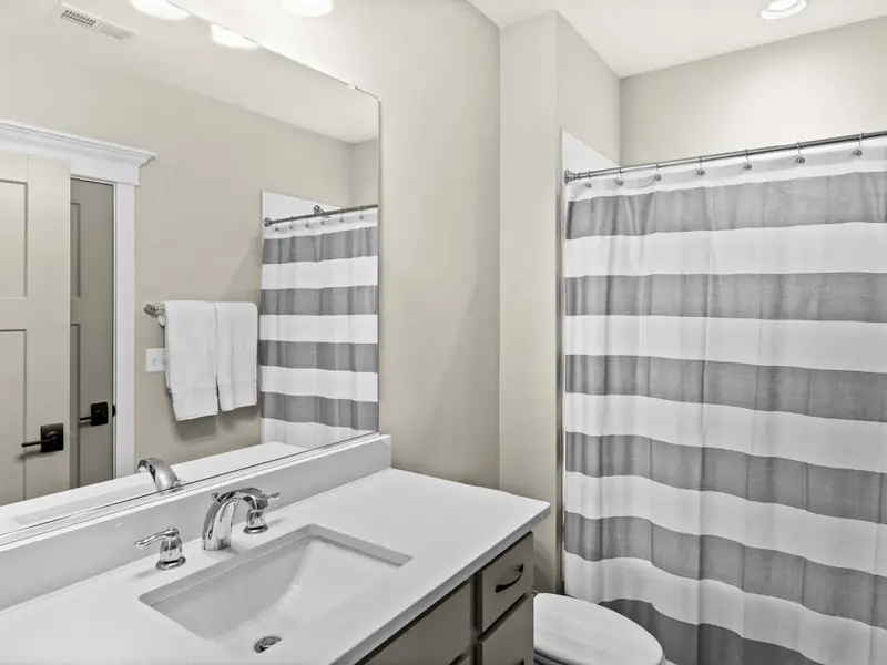 Bathroom - The lower-level hall bathroom with vanity and bright lighting, shared between the game and bunk rooms.