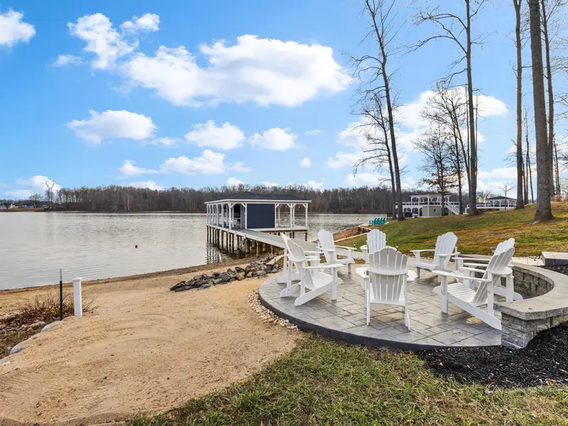 Boathouse - Fire pit and boathouse in the same frame, showing the full arc from the house to the waterline.