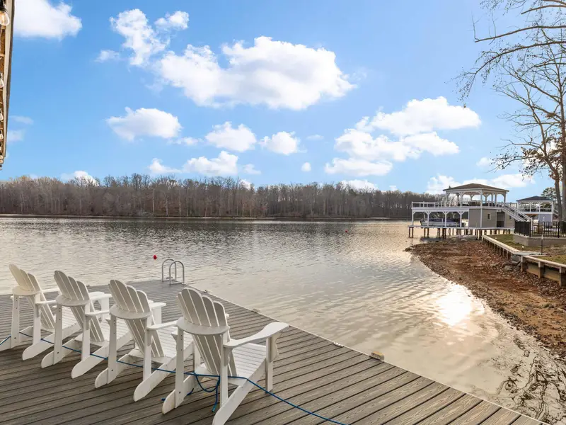 Boathouse - Adirondack chairs on the dock deck face the open lake, with the covered slip providing shade alongside.