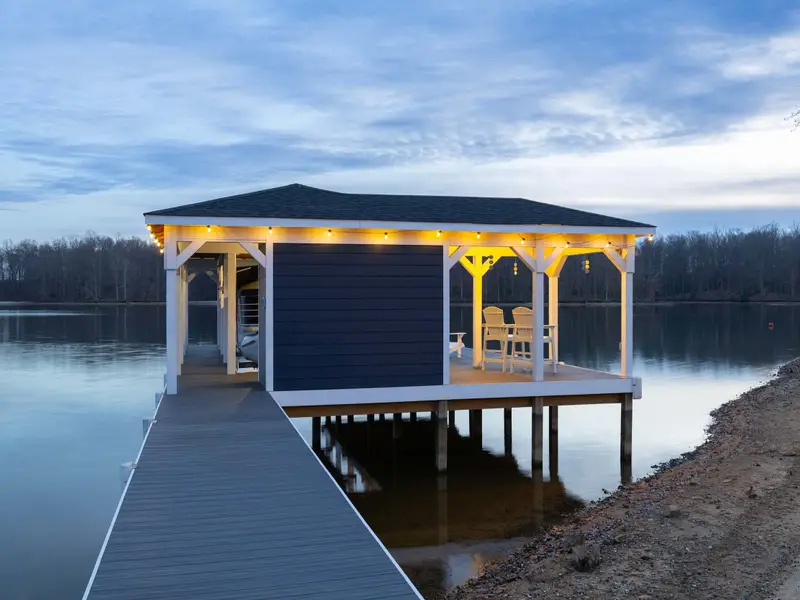 Boathouse - The boathouse lit up at dusk, its white structure perfectly reflected in the calm dark water.