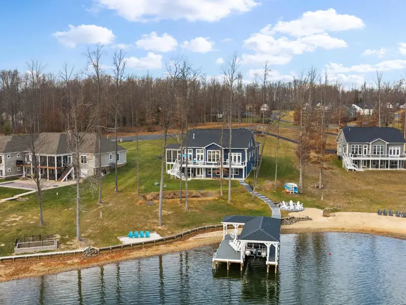 Exterior - An aerial from the lake shows the house, fire pit, beach area, and boathouse as a complete lakefront package.