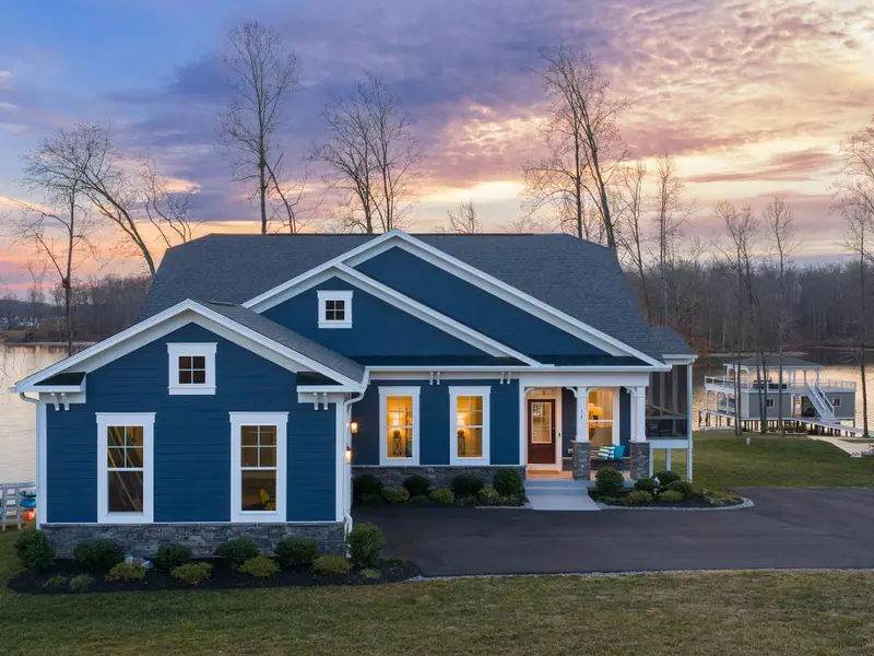 Exterior - A sunset aerial from the front shows the craftsman exterior glowing under a purple and pink sky.