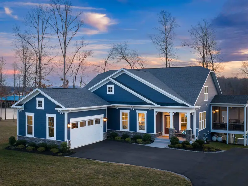 Exterior - The front of Fairview Lake Haven at dusk, garage, porch, and boathouse all lit against the darkening sky.