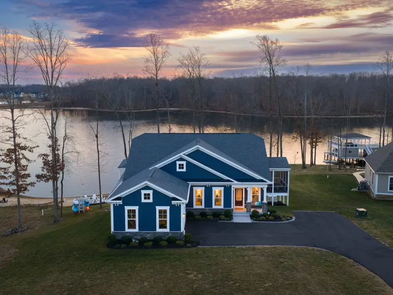 Exterior - Fairview Lake Haven from the front at sunset, craftsman blue and white against a golden lake horizon.
