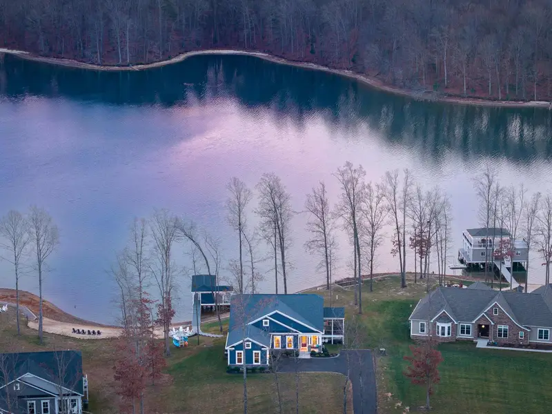 Exterior - The house lit from within at dusk, the lake colors reflecting perfectly in the still water below.