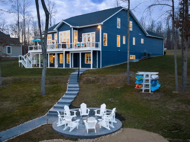 Fire Pit - Adirondack chairs, the dock path, the kayak rack, and the house behind, a place to stay long after the sun goes down.