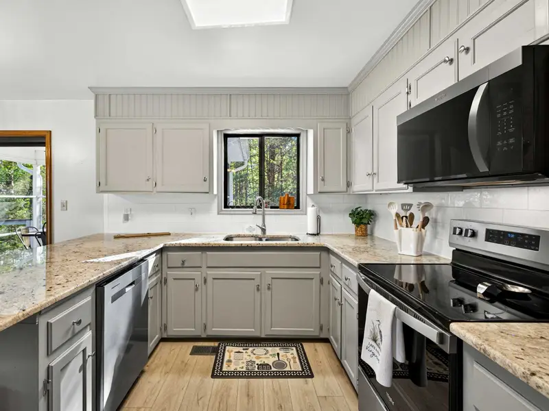 Modern Cleanup: High-arc faucet and double sinks overlooking the backyard.