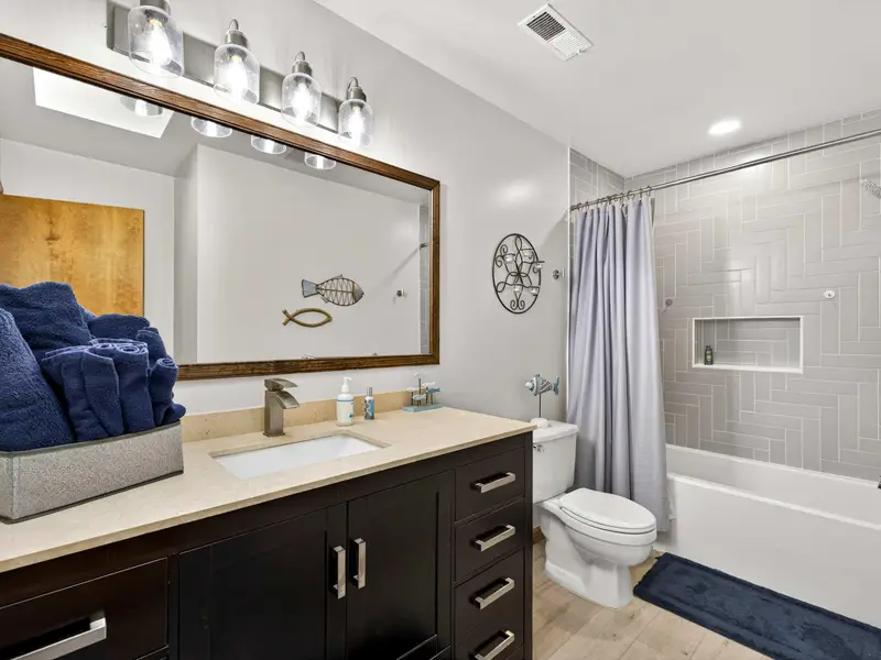 Upper Level Bath: Modern finishes and bright lighting for your guests.