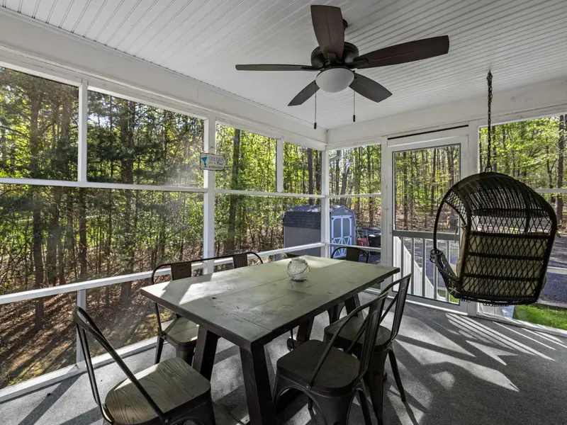Porch Comfort: Plush cushions and panoramic views of the woods.