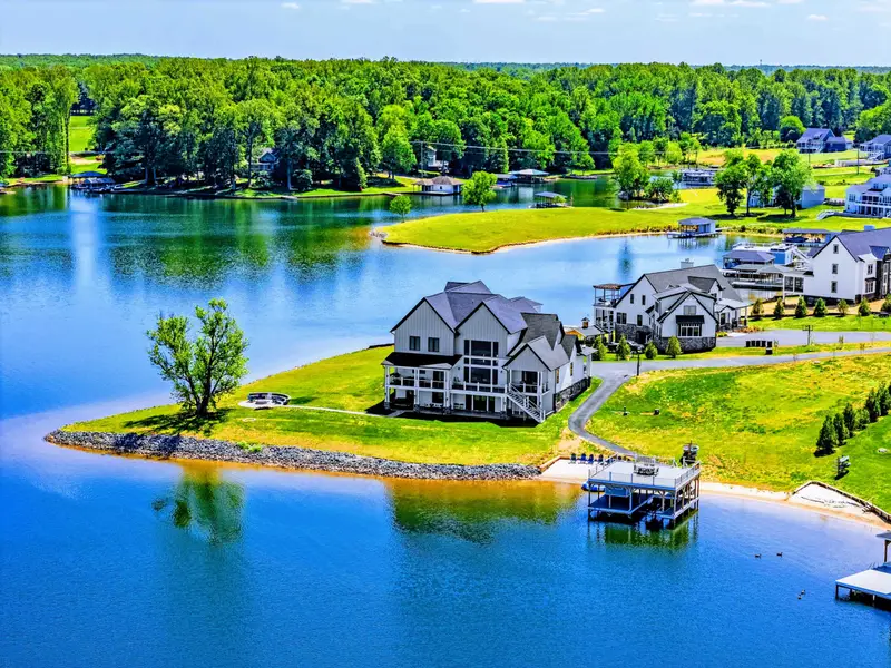 Exterior - Aerial of the home from over the water. Private peninsula, sweeping lawn, dock anchored at the point.