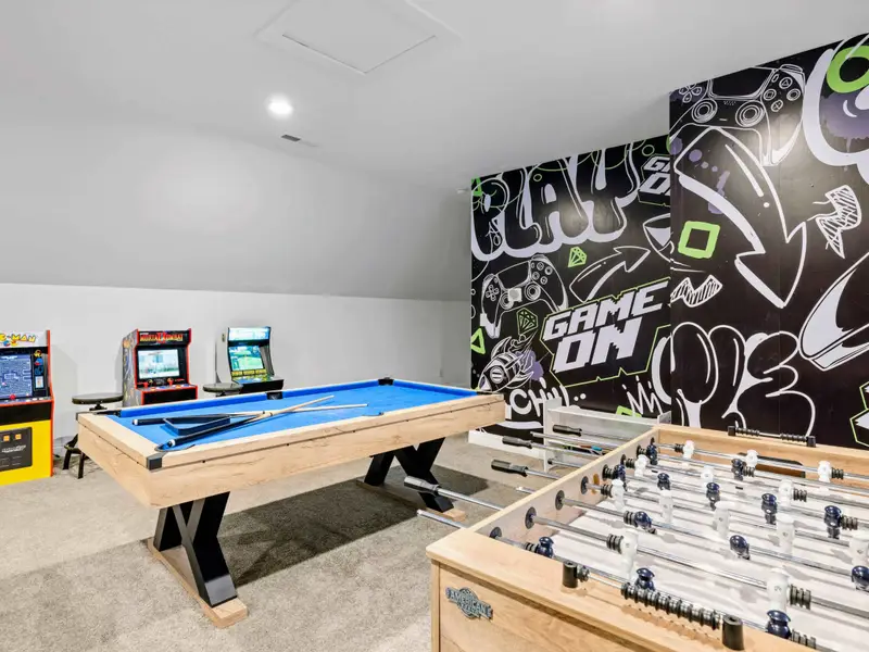Game Room - Pool table, foosball, and a wall of arcades under a 'GAME ON' mural, this is where rainy days end up.