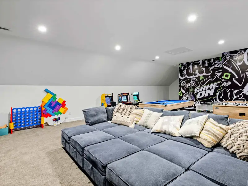Game Room - Modular sectional facing the action: pool table, arcades, foosball, and giant Connect 4 within reach.