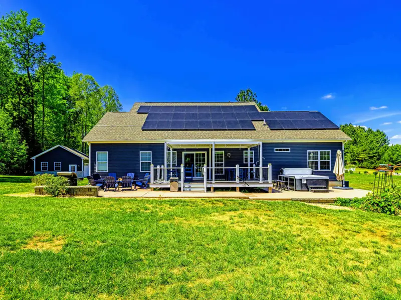Backyard - Generous lawn, covered back porch, fire pit lounge, and hot tub all set for a long weekend at the lake.