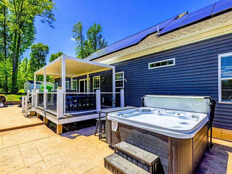 Hot Tub - Tucked beside the deck on the stamped patio, with the pergola dining area a few steps away.