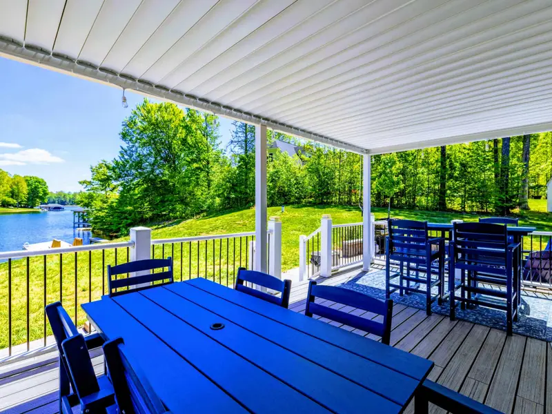 Back Porch - Dining table, bar seating, and an open view to the lake just past the railing.
