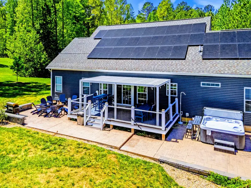 Aerial - Louvered pergola over the porch, fire pit lounge to one side, hot tub to the other, all ready for the day.