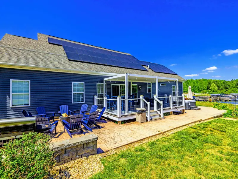 Back Deck & Fire Pit - Stamped patio with Adirondacks circled at the fire pit, marina views beyond.