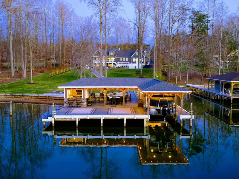 Backyard - The home sits up the slope from the waterfront, with the dock, sandy beach, and boathouse spread out below.