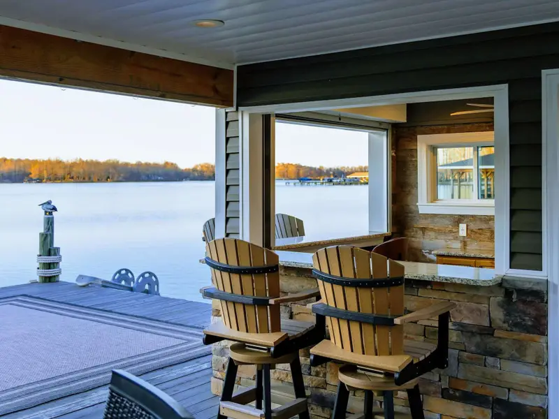 Backyard - A green lawn slopes toward the dock, framed by quiet coves and open water beyond.