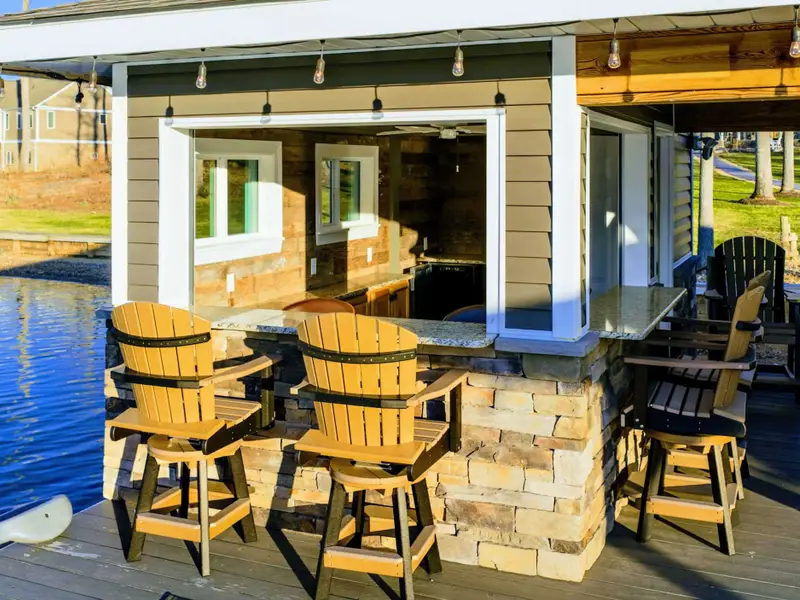 Backyard - The home sits up the slope from the waterfront, with the dock, sandy beach, and boathouse spread out below.