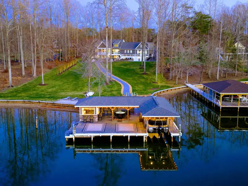 Backyard - The home sits up the slope from the waterfront, with the dock, sandy beach, and boathouse spread out below.