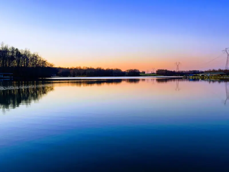 Backyard - A green lawn slopes toward the dock, framed by quiet coves and open water beyond.
