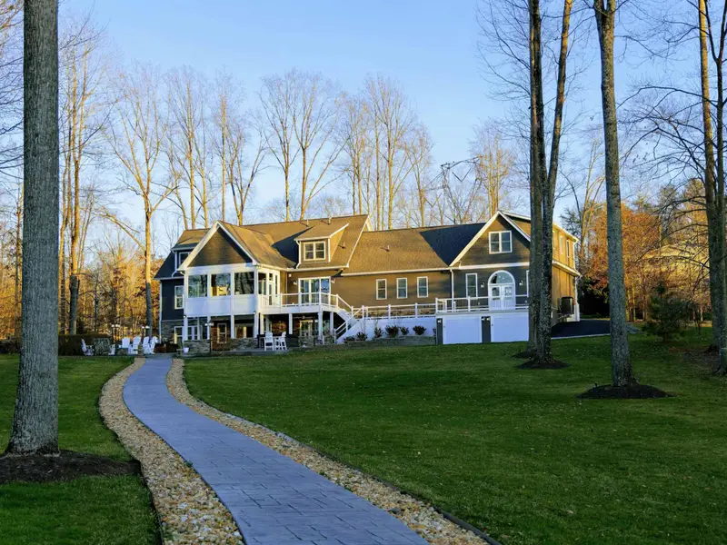 Backyard - A green lawn slopes toward the dock, framed by quiet coves and open water beyond.