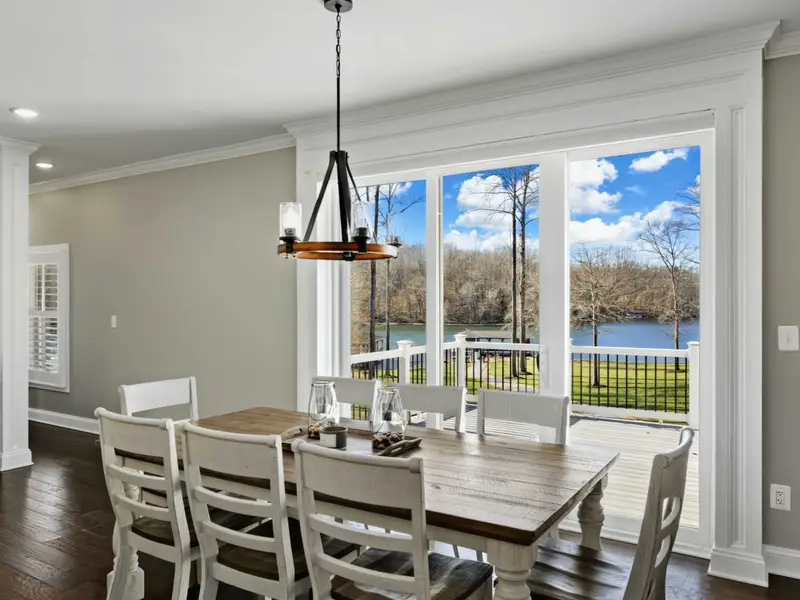 Dining Area - A large dining table seats the whole group, with the kitchen steps away and the lake through the windows.