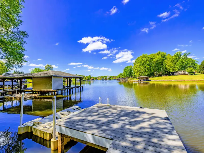 Backyard - Sloped, wooded yard offers privacy and shade between the house and the water.