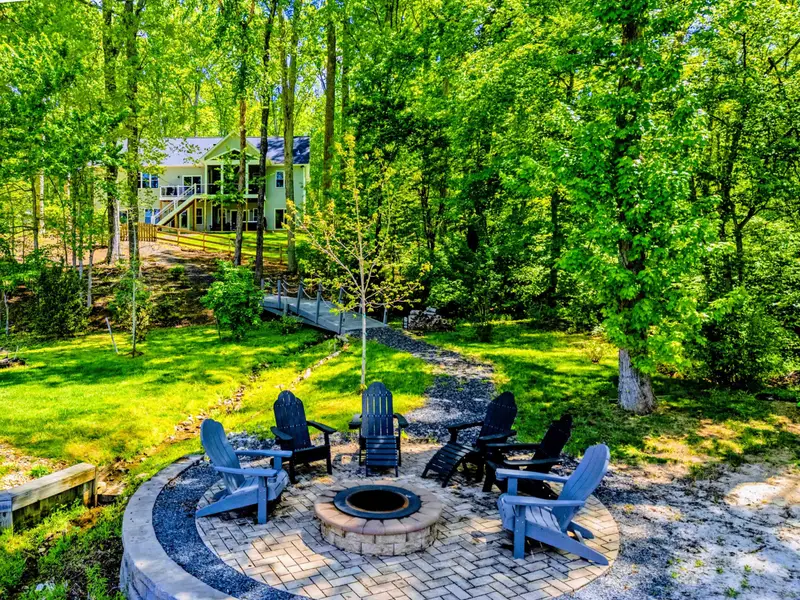 Backyard - Stone path leads from the house through the trees toward the water.