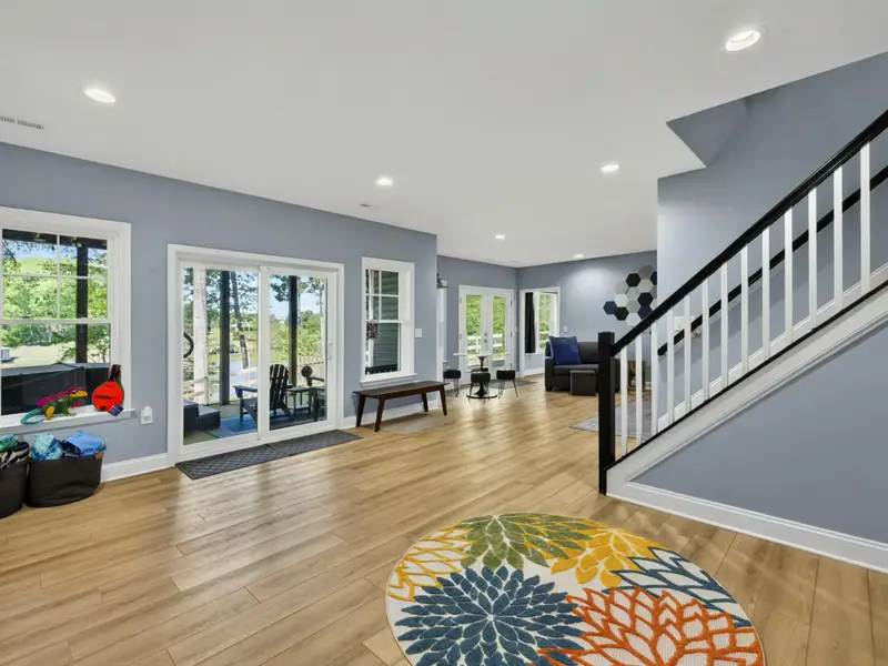Game Room - Stairs lead up to the main level with light wood treads.