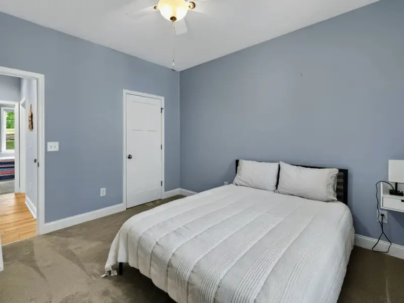 Bedroom 3 - Light blue walls, ceiling fan, and a queen bed for two.