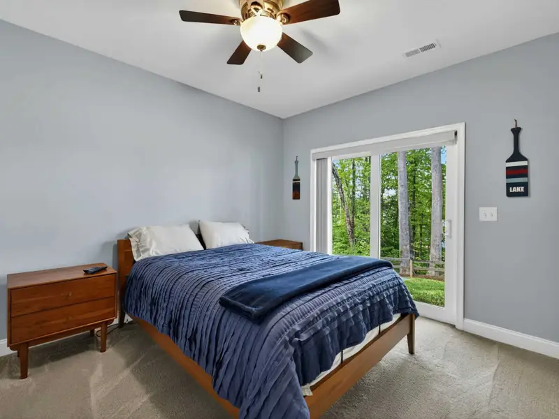Bedroom 5 - Mounted TV, ceiling fan, and sliding doors to the lower patio.